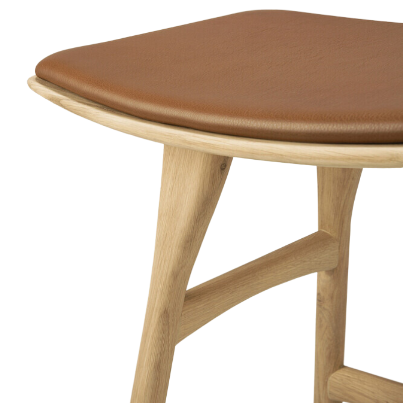 The Upholstered Osso Dining Stool from Ethnicraft with oak and cognac leather close up.