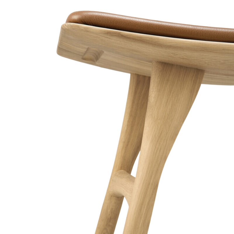 The Upholstered Osso Dining Stool from Ethnicraft with oak and cognac leather in detail.