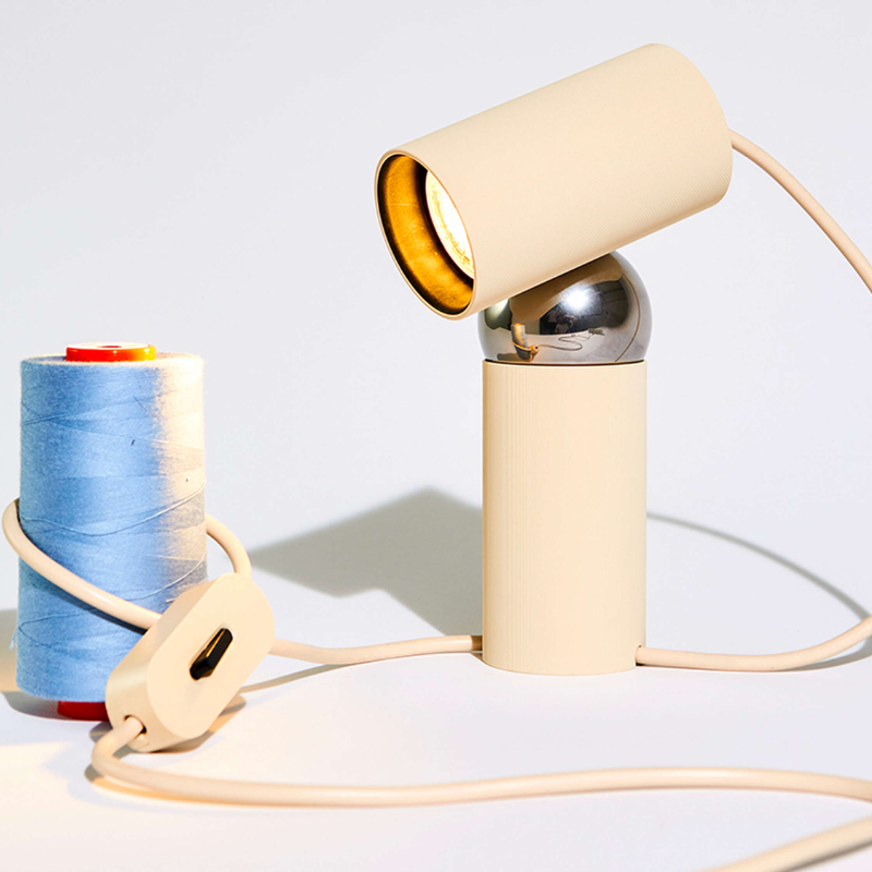 The Bilboquet Table Lamp from FLOS in linen in a studio.