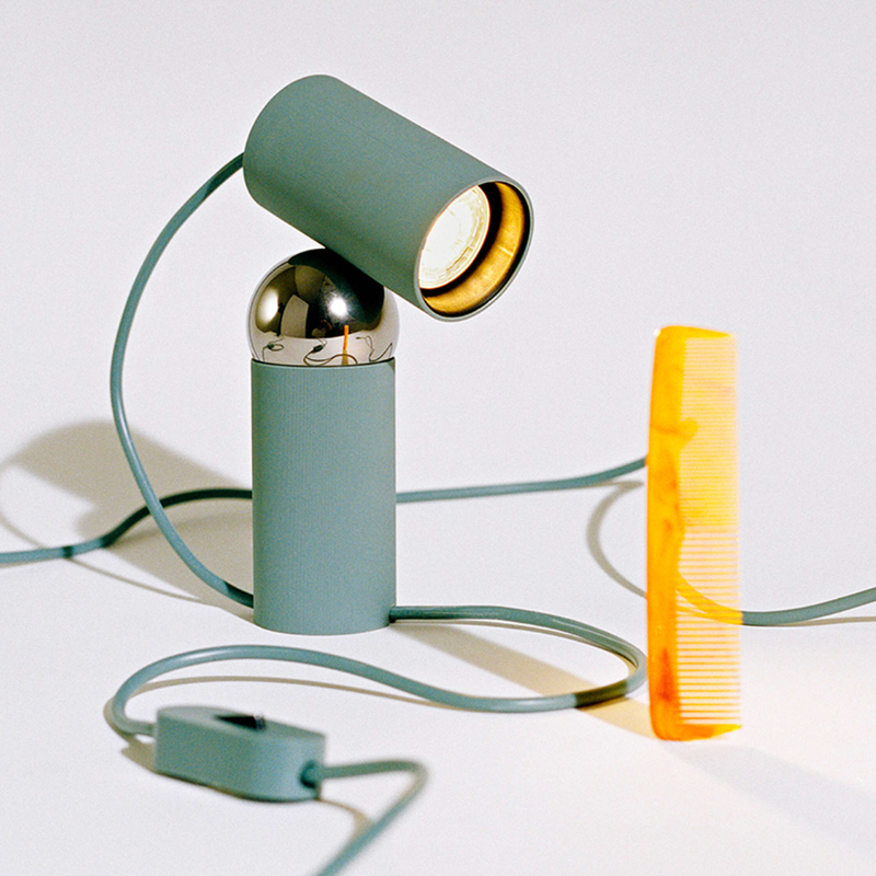 The Bilboquet Table Lamp from FLOS in sage in a studio.