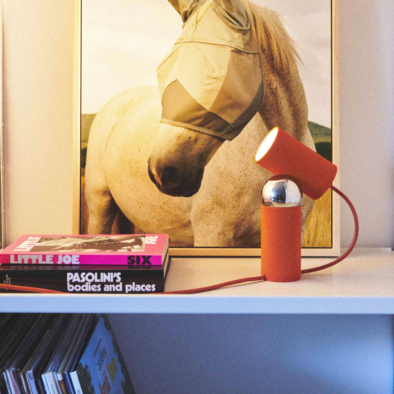 The Bilboquet Table Lamp from FLOS in tomato in an office.