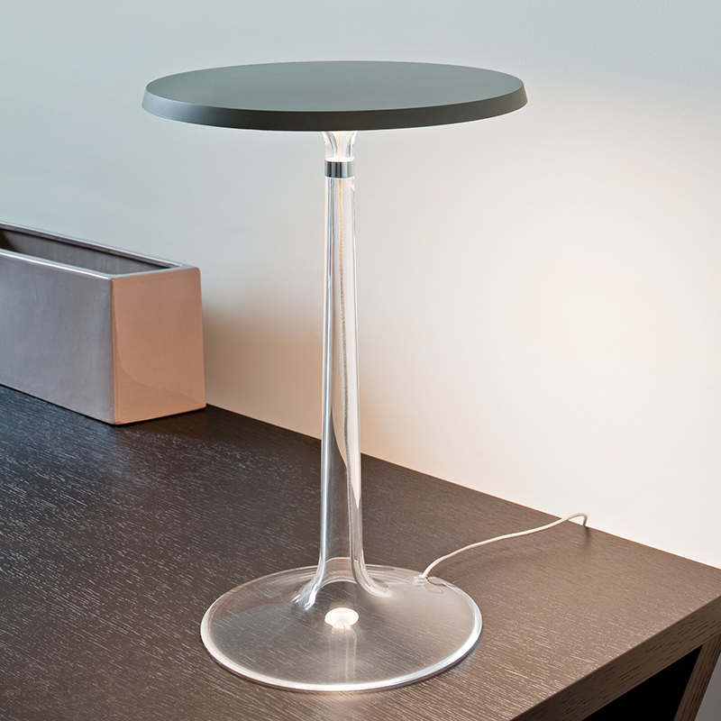 The Bon Jour Table Lamp from Flos in matte chrome with fumee crown in a bedroom.