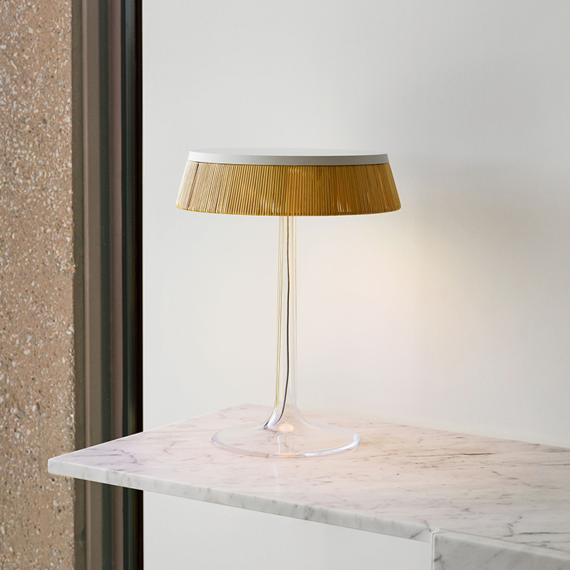 The Bon Jour Table Lamp from Flos in white with rattan crown in an office.