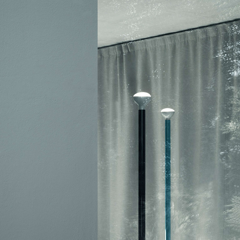 The Luminator Floor Lamp from FLOS in anthracite in a bedroom.