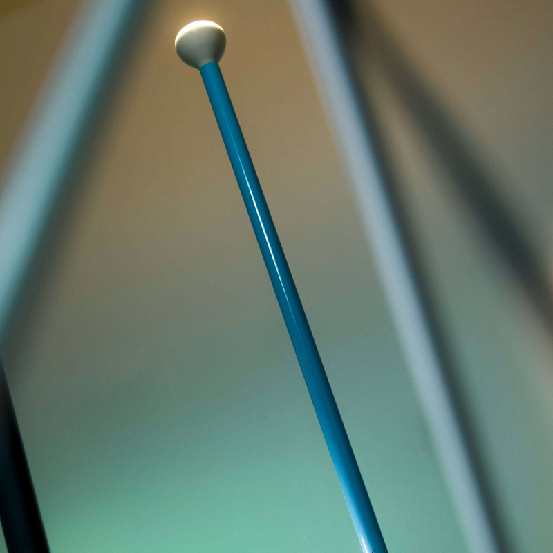 The Luminator Floor Lamp from FLOS in lite blue in a living room.