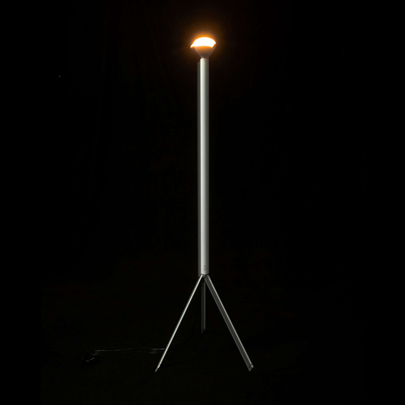 The Luminator Floor Lamp from FLOS in white in a dark room.