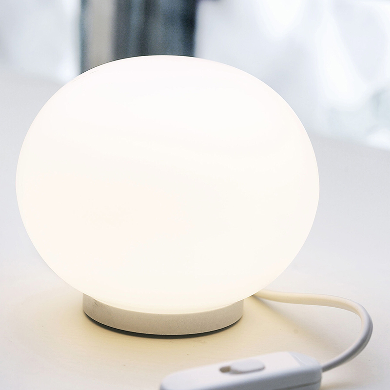 The Mini Glo-Ball Table Lamp from Flos in a home office.