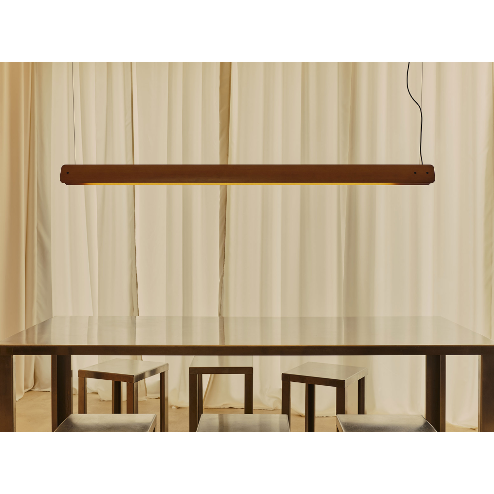 The Seki-Han Linear Pendant by FLOS over a dining table turned on.
