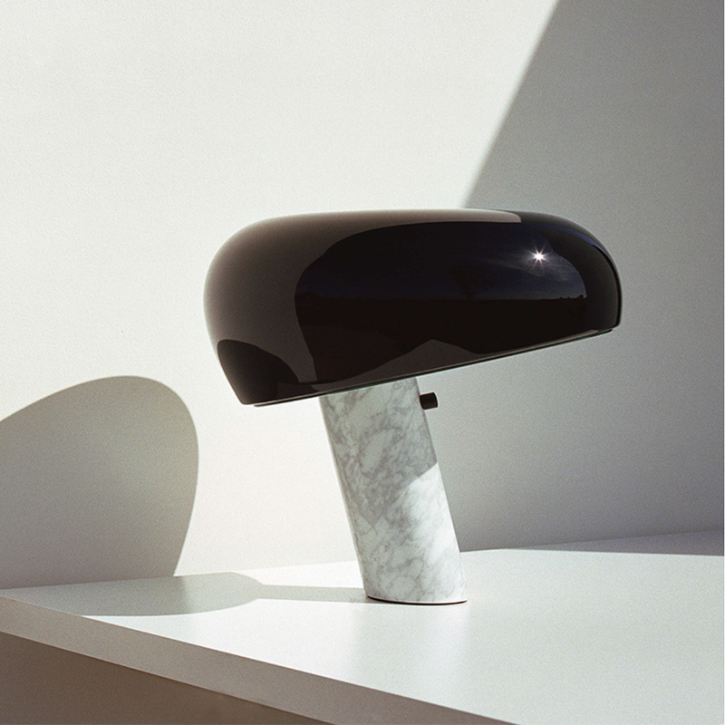 The Snoopy Table Lamp from FLOS in black in a study.