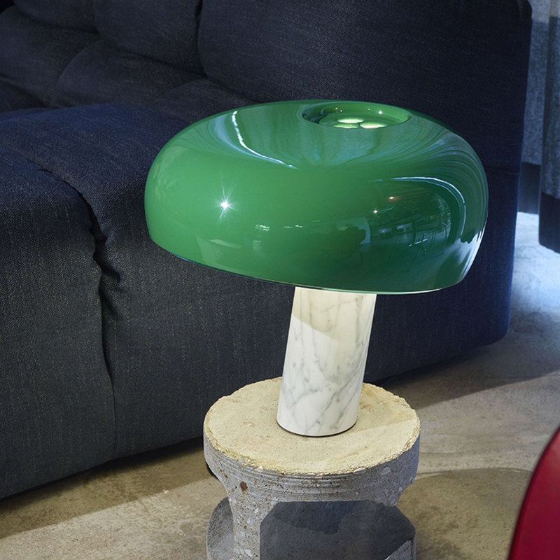 The Snoopy Table Lamp from FLOS in green in a living space.