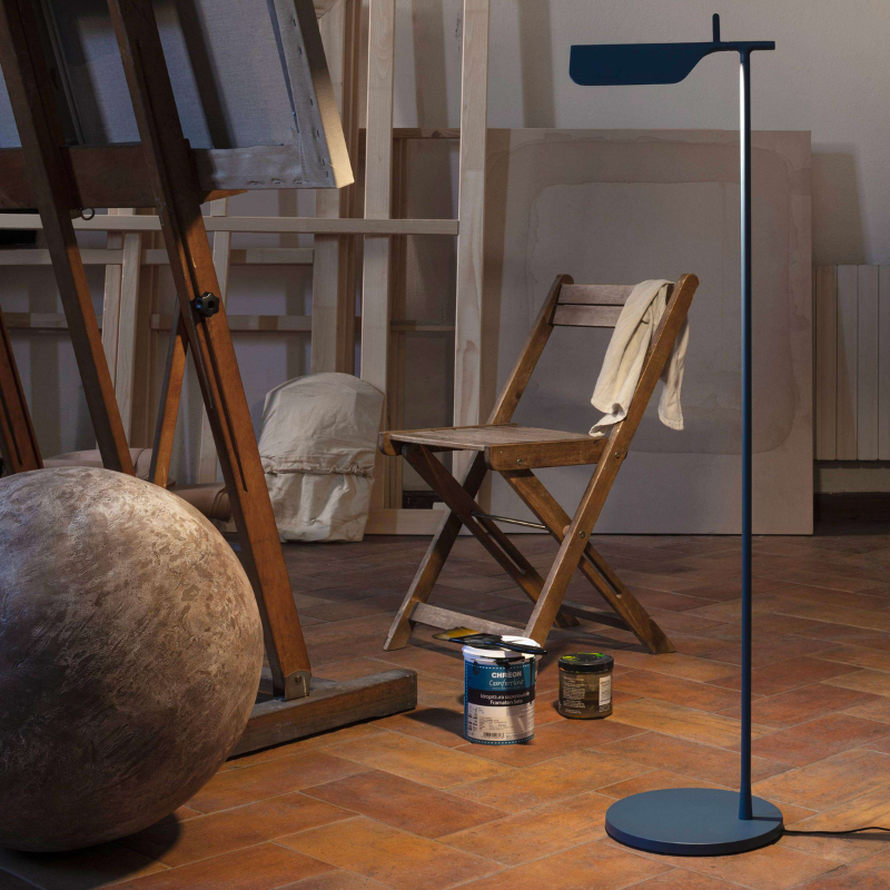 The Tab Floor Lamp from FLOS in matte blue in an art studio.