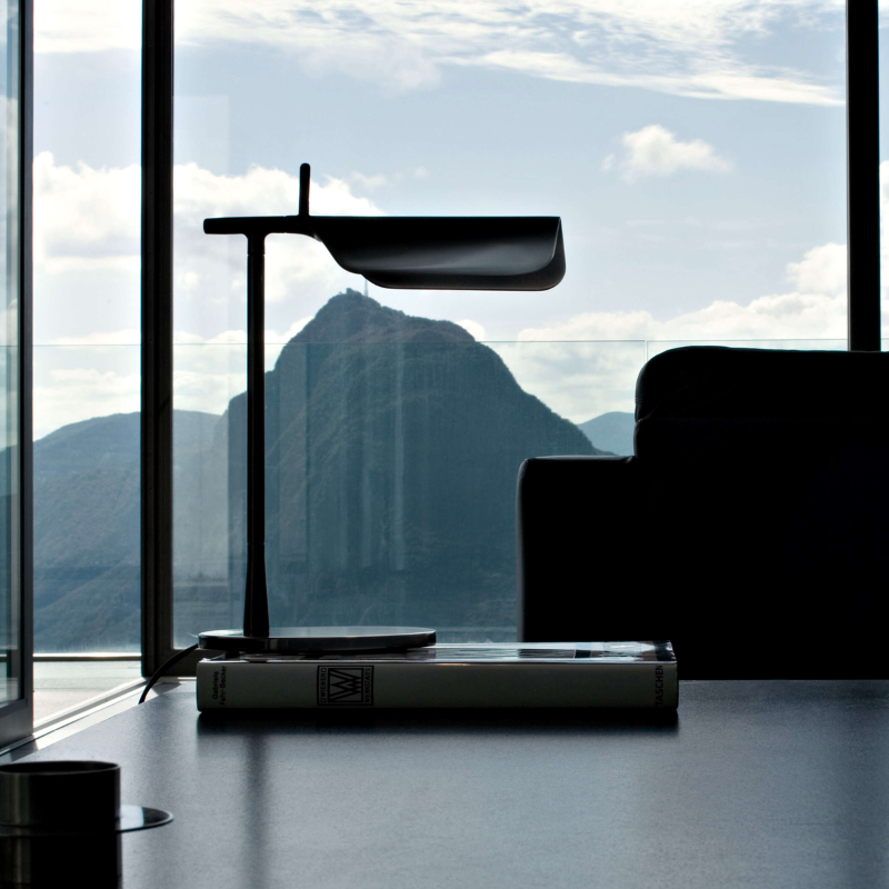 The Tab Table Lamp from FLOS in black in an office.