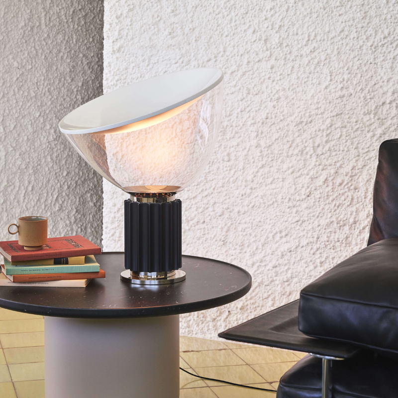 The small Taccia Table Lamp from FLOS in black in an office.