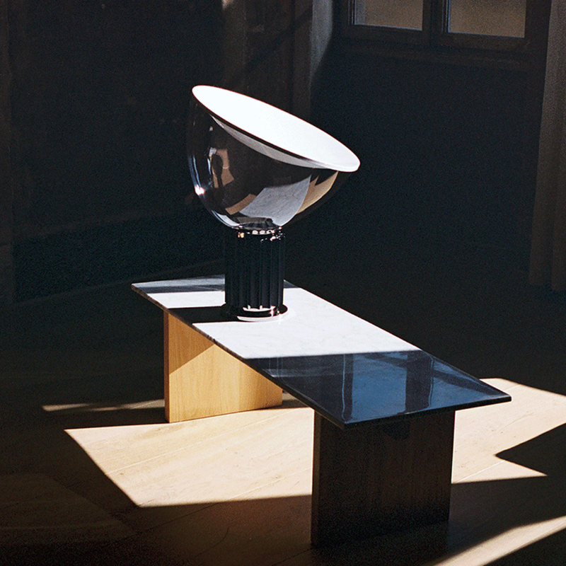 The standard Taccia Table Lamp from FLOS in black in a lounge.