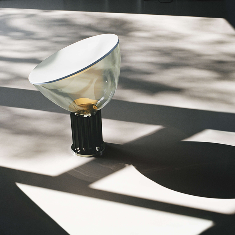 The standard Taccia Table Lamp from FLOS in black in a studio.