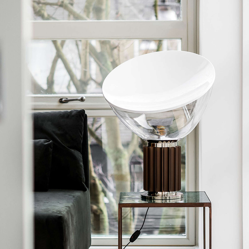The standard Taccia Table Lamp from FLOS in bronze in a living room.