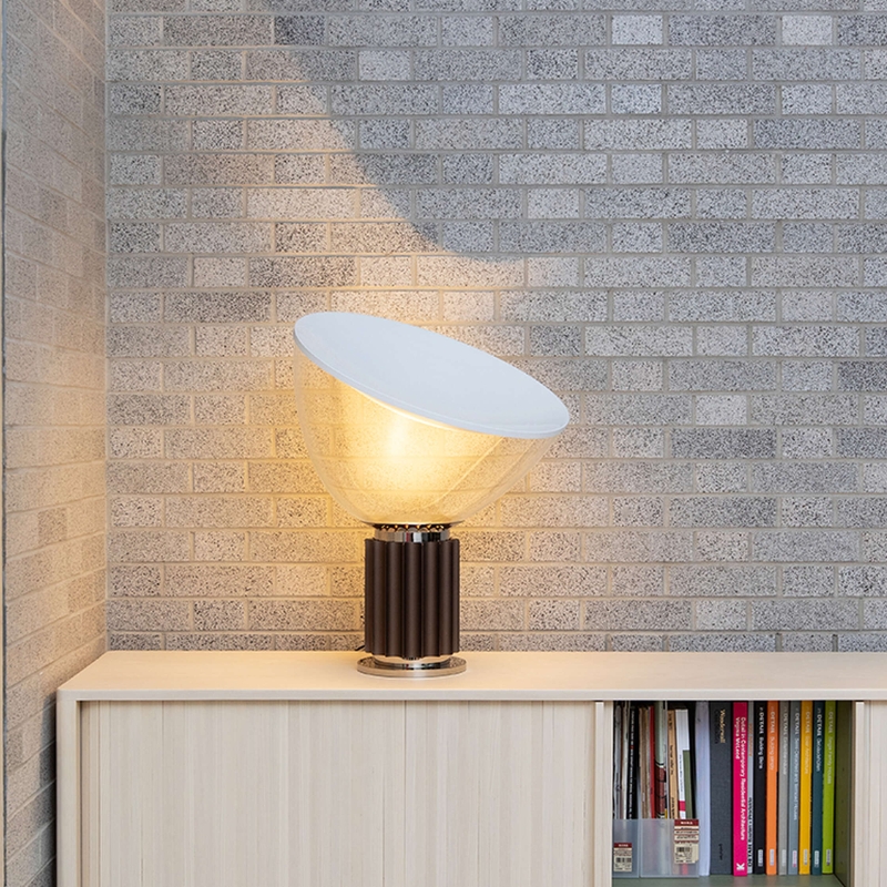 The standard Taccia Table Lamp from FLOS in bronze in a primary bedroom.