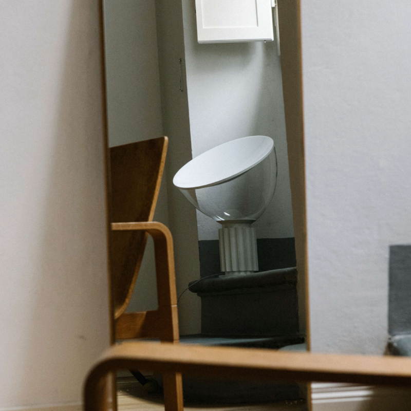 The standard Taccia Table Lamp from FLOS in matte white in a bedroom.