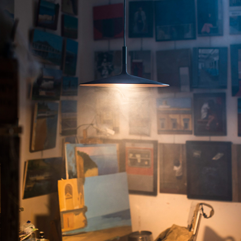 The Aplomb Large Pendant from Foscarini in anthracite in a bedroom.