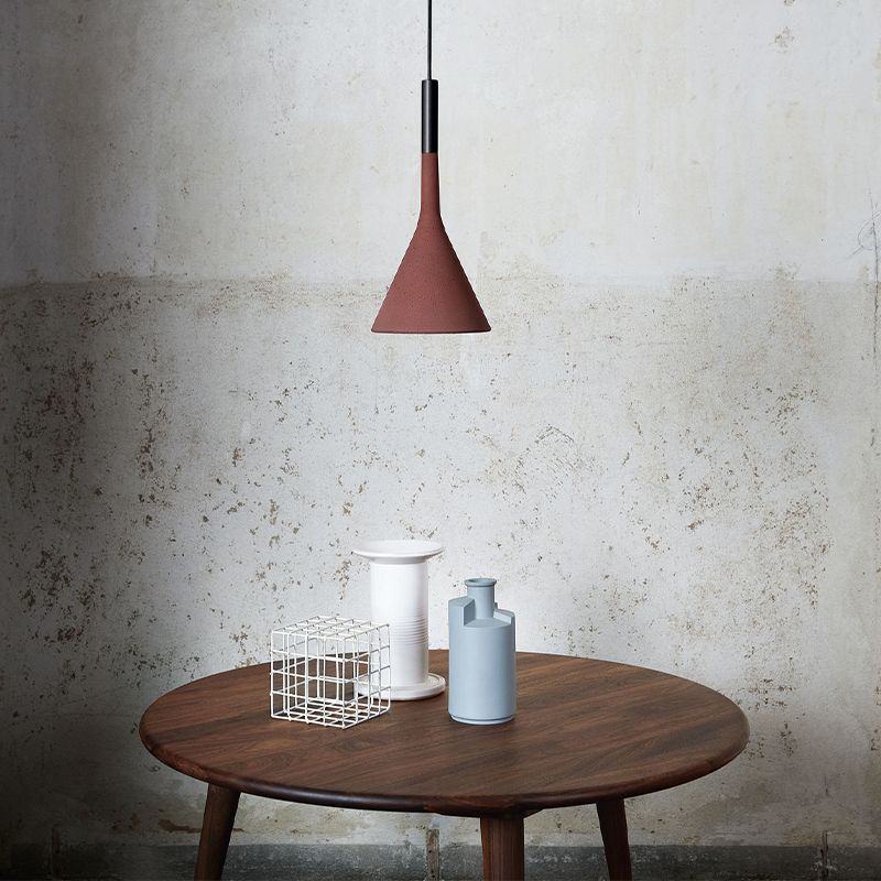 The Aplomb Pendant from Foscarini in brick red in an office.