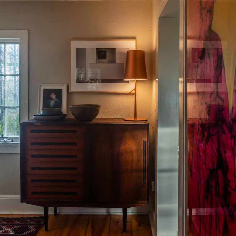 The Birdie Table Lamp from Foscarini in copper in a bedroom.