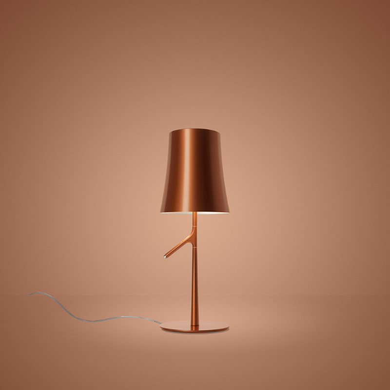 The Birdie Table Lamp from Foscarini in copper in a studio.