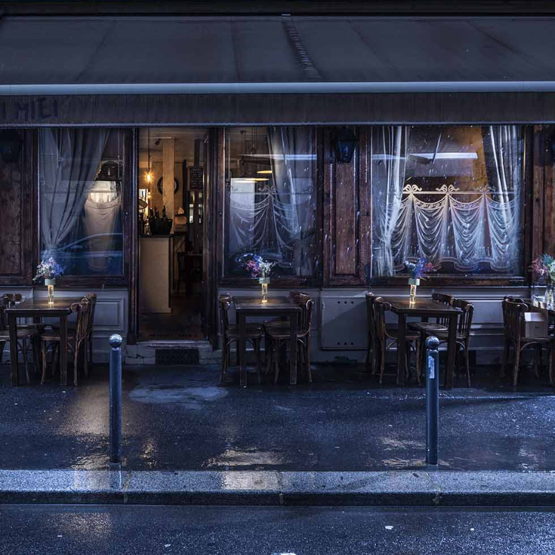 The Fleur Portable Lamp from Foscarini in sage green outside a restaurant.