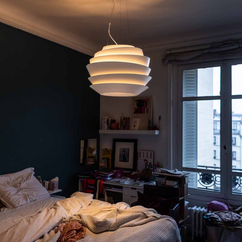 The Le Soleil Pendant from Foscarini in a bedroom.