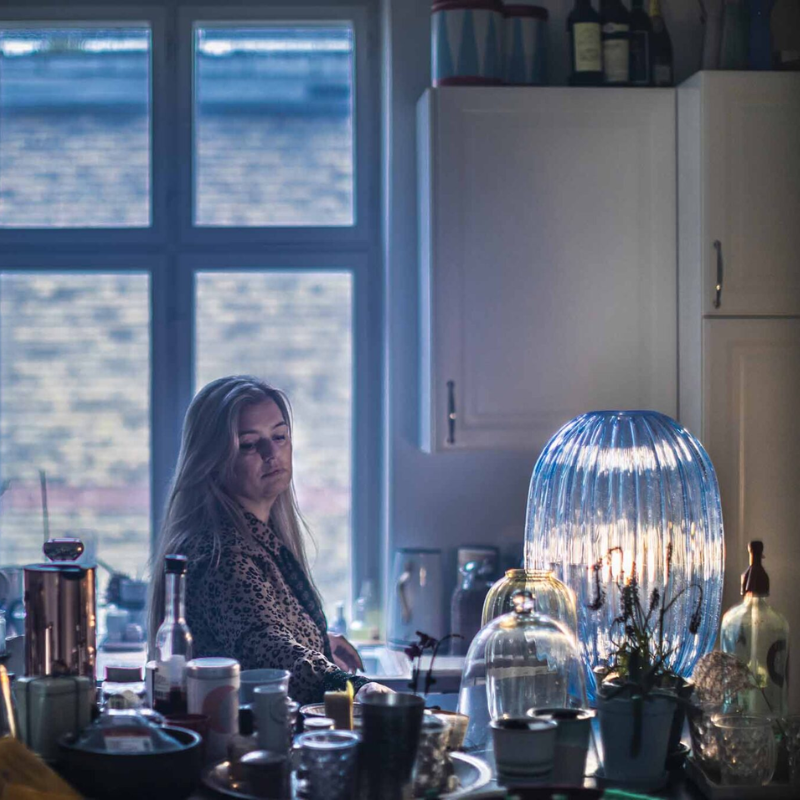 The Plass Table Lamp from Foscarini in light blue in a kitchen.