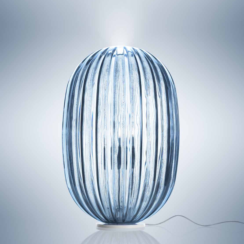 The Plass Table Lamp from Foscarini in light blue in a studio.