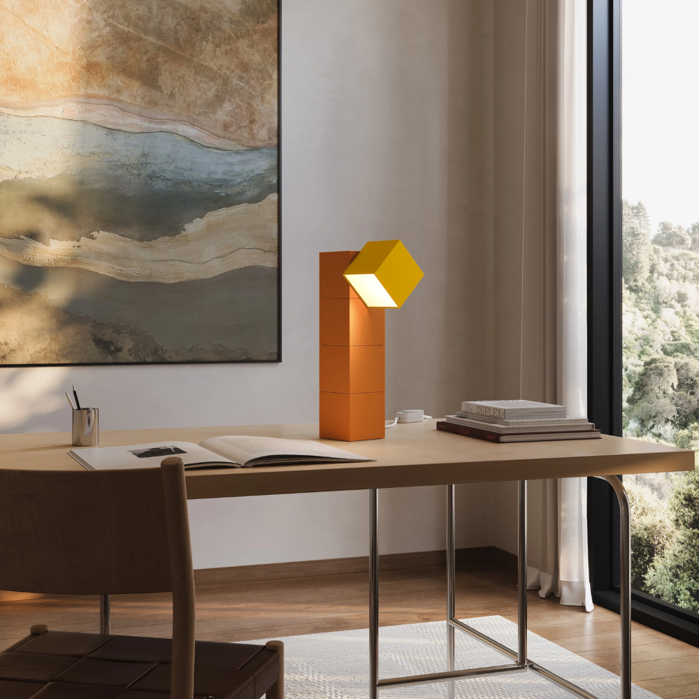 The persimmon Analog Task Light from Gantri in a home office on top of a desk.
