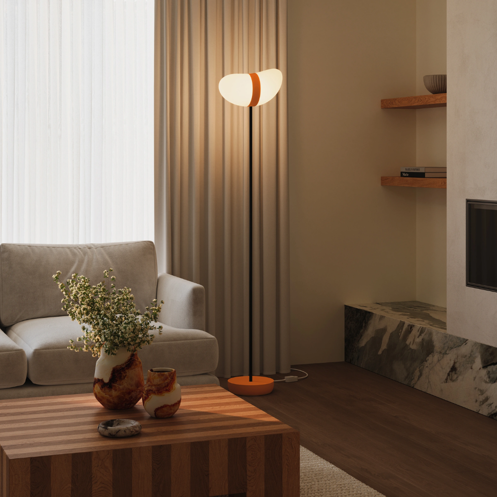 The persimmon Baltra Floor Light from Gantri with the black rod option in a living room.