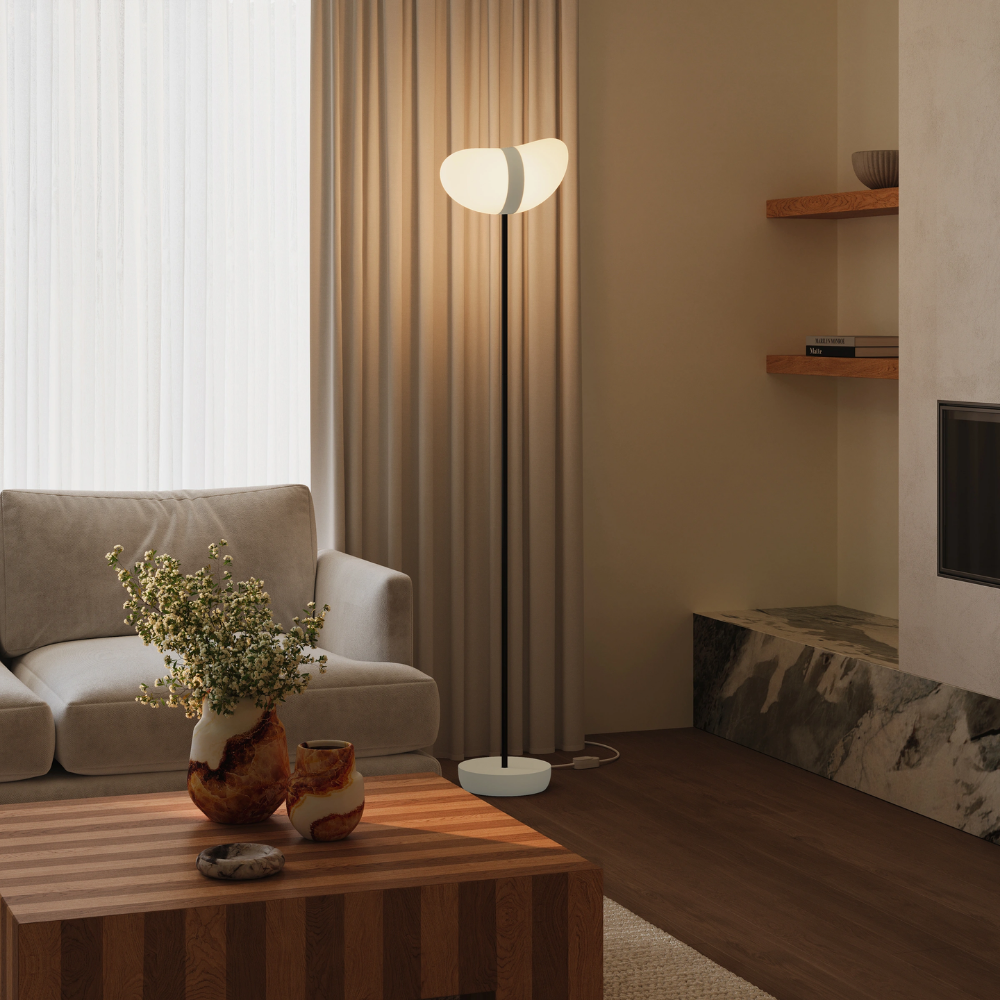 The sand Baltra Floor Light from Gantri with the black rod option in a living room.