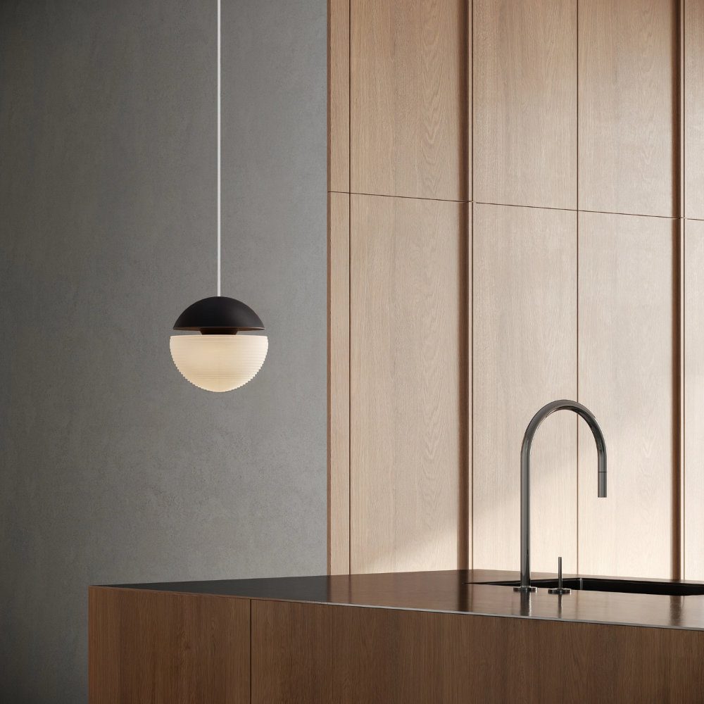The carbon Cora Pendant Light from Gantri with the white cord in a living area.