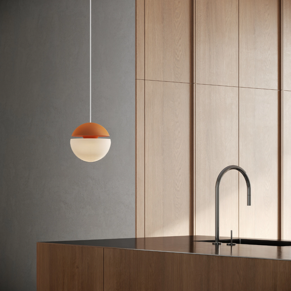 The persimmon Cora Pendant Light from Gantri with the white cord in a living room.
