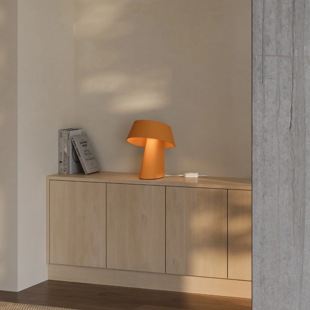 The persimmon Fold Table Light from Gantri in a living room.