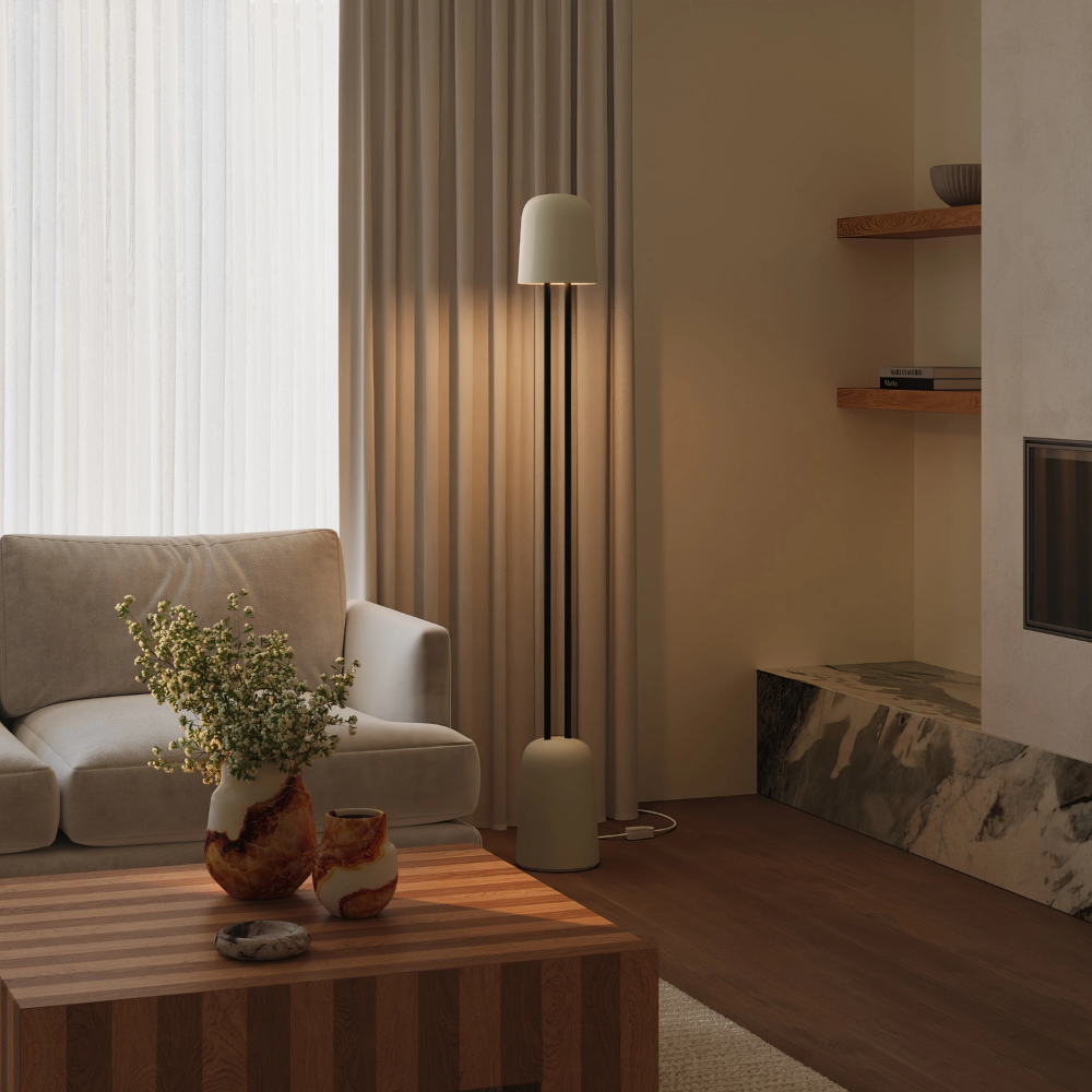 The sand Gio Floor Light from Gantri with the black rod option in a living room near a couch.