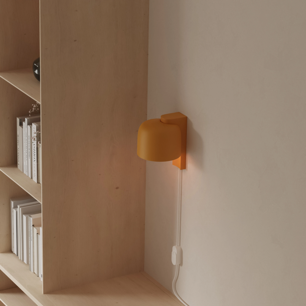 The mustard Gio Wall Light from Gantri in a home office.