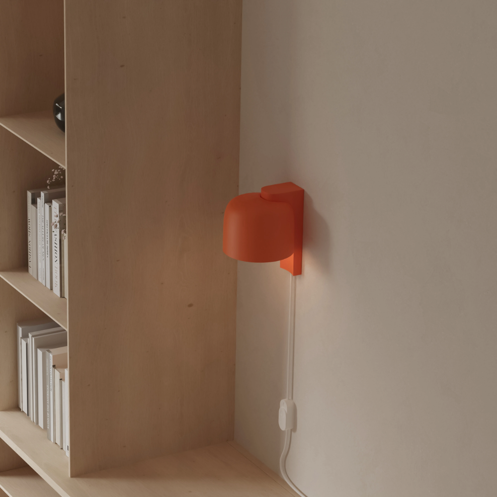 The persimmon Gio Wall Light from Gantri in a home office.