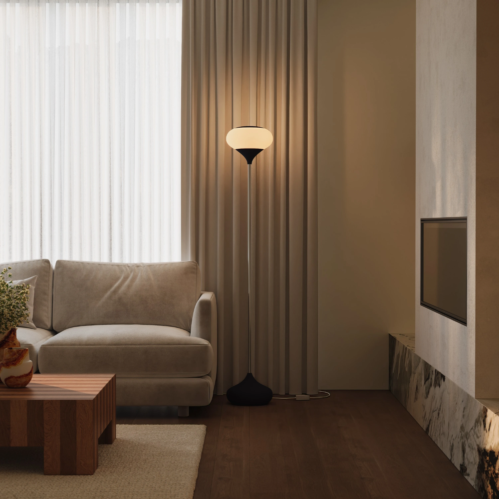 The carbon Kobble Floor Light from Gantri with the chrome rod option in a family area near a fireplace.