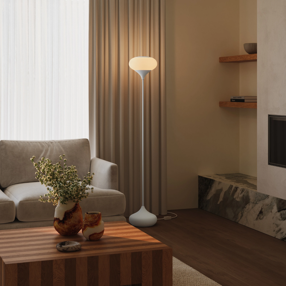 The snow Kobble Floor Light from Gantri with the white rod option in a lounge space next to a sofa.
