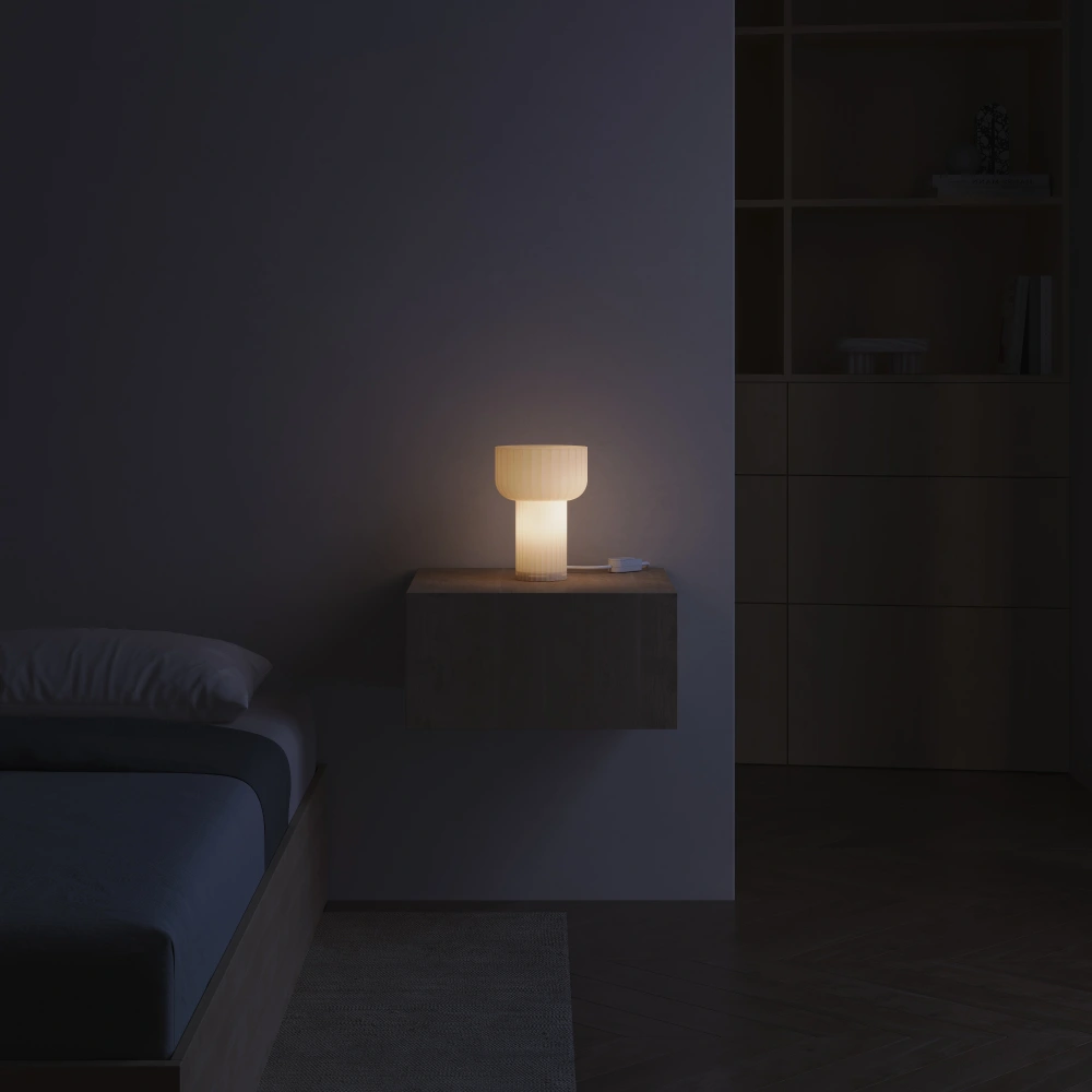 The Word Table Light from Gantri in a bedroom used as a bedside light at night.