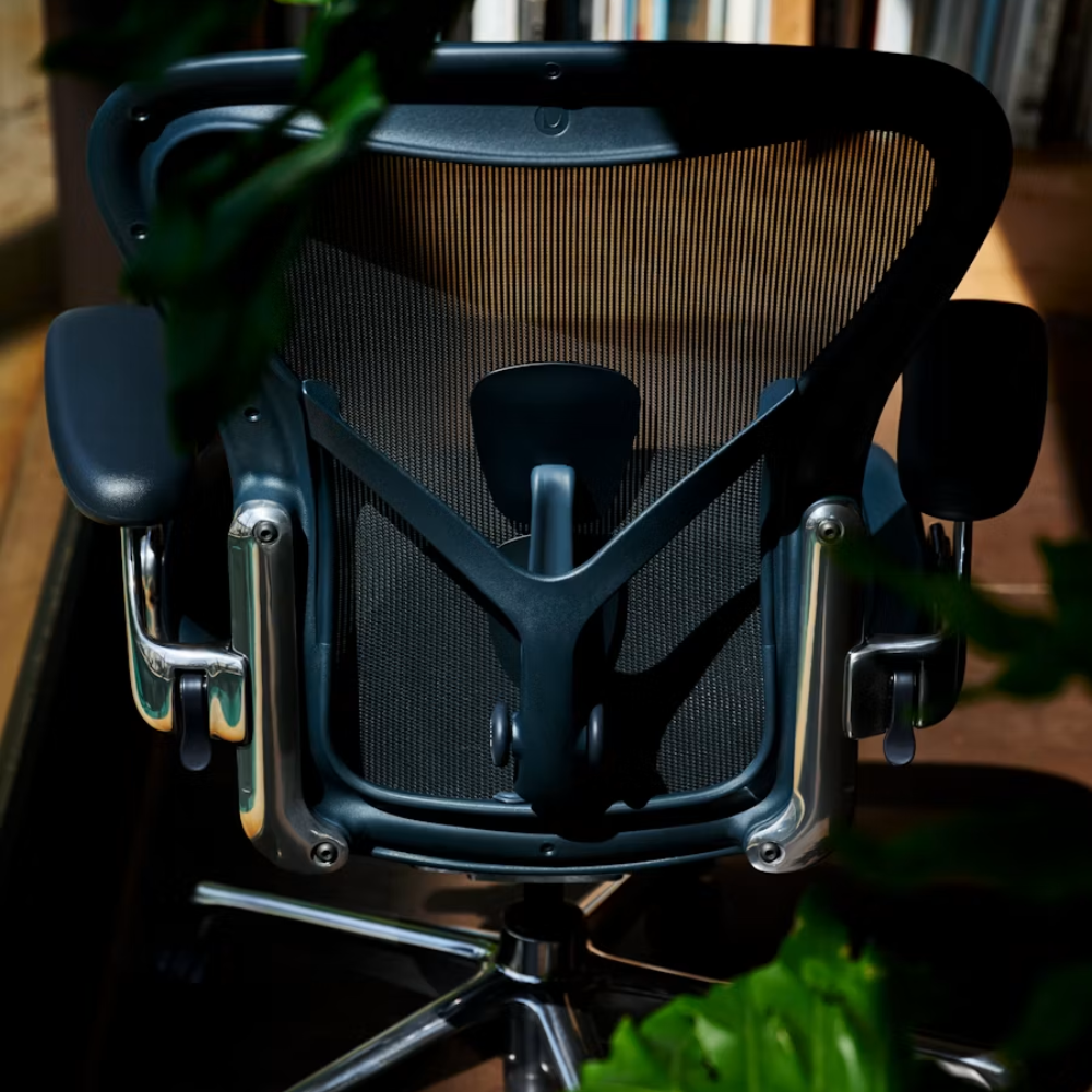 The Aeron Chair from Herman Miller with the adjustable Posturefit SL back support in Nightfall / Chrome from the rear in a home office.