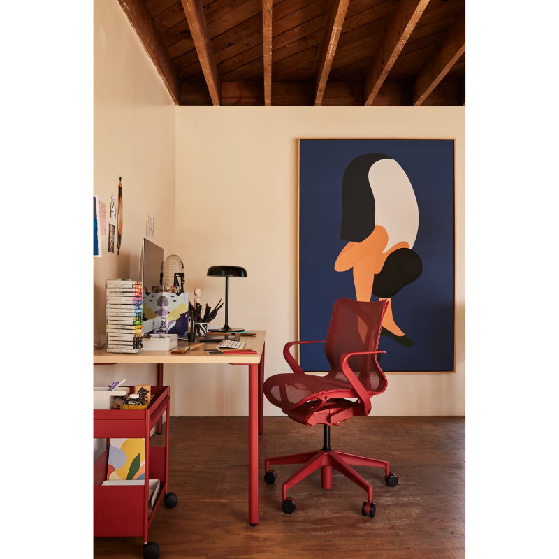 The canyon Cosm Office Chair with low back and fixed arms from Herman Miller in a home workspace.