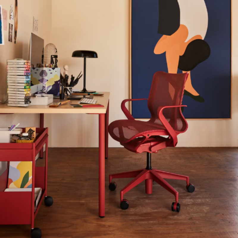 The canyon Cosm Office Chair with low back and fixed arms from Herman Miller in a home workspace.