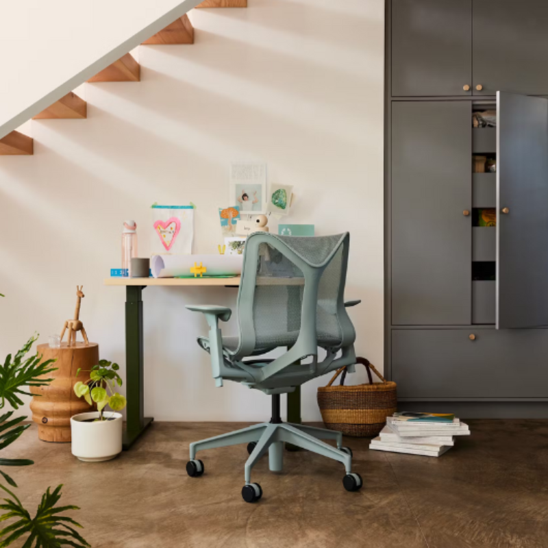 The glacier Cosm Office Chair from Herman Miller in a living room near a kitchen.