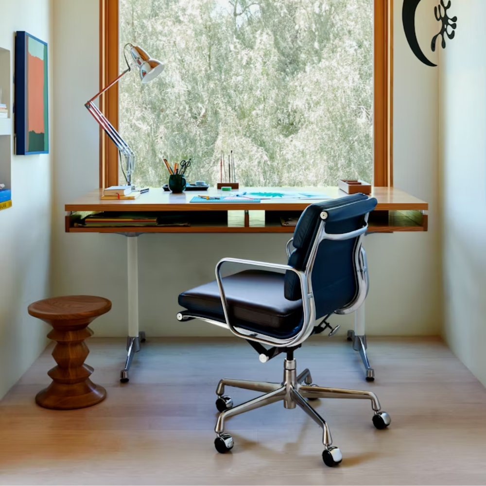 The walnut Eames 2500 Series Executive Desk from Herman Miller in a workspace.