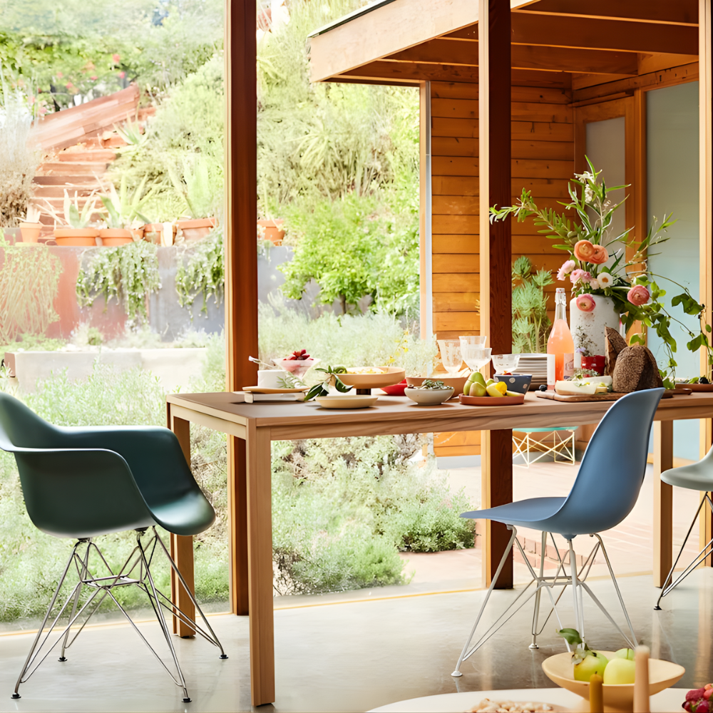 The evergreen shell Eames Molded Plastic Armchair Wire Base from Herman Miller in a dining room.