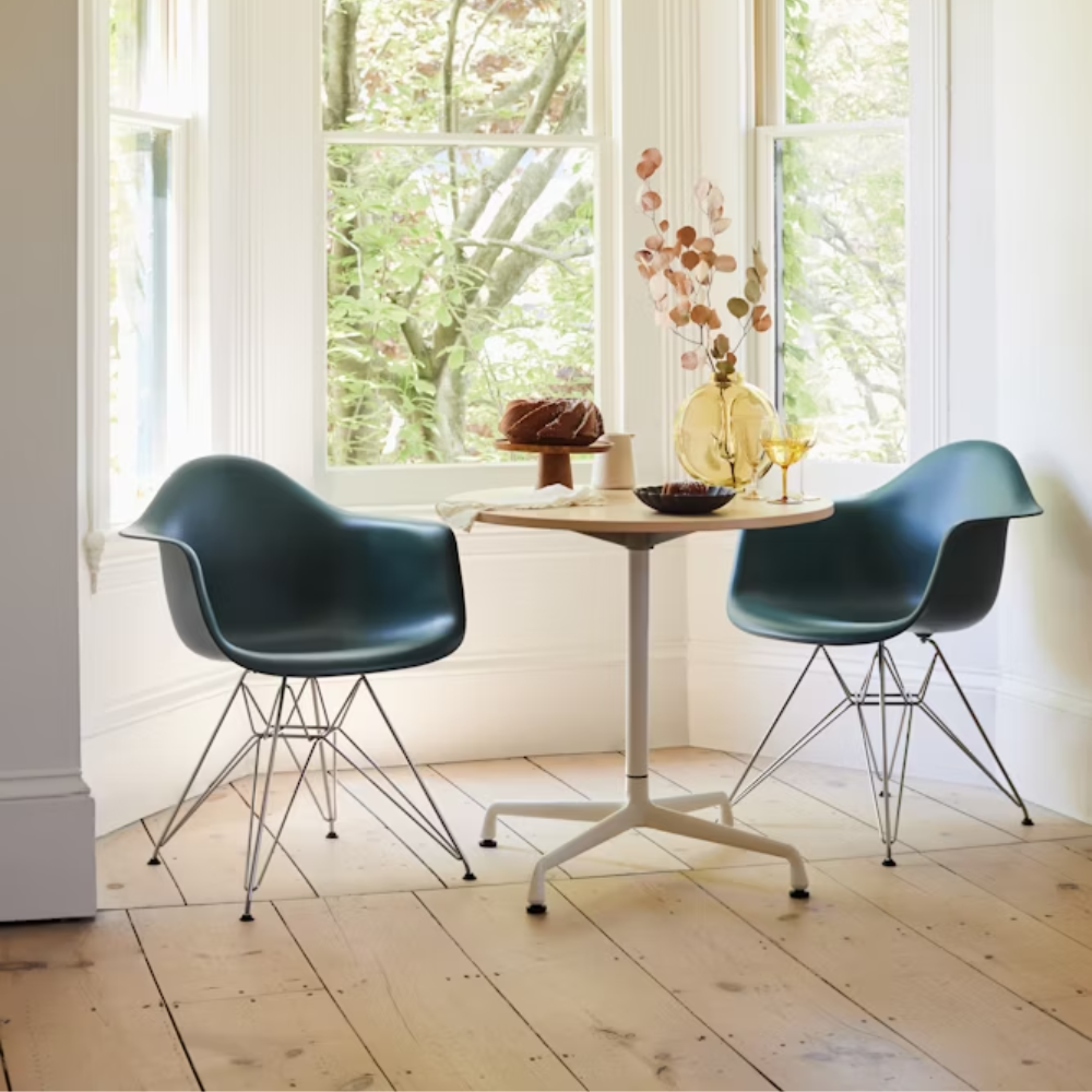 The evergreen shell Eames Molded Plastic Armchair Wire Base from Herman Miller in a living room.