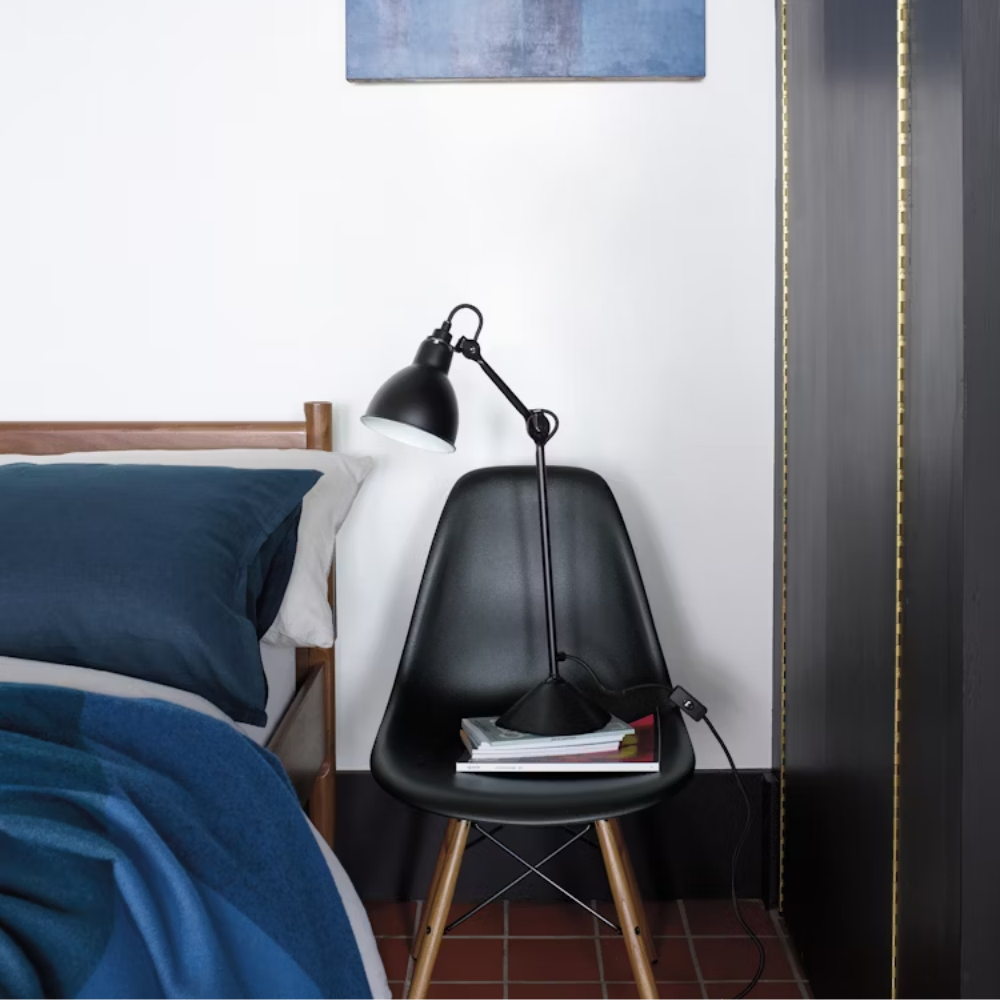 The black shell Eames Molded Plastic Side Chair Dowel-Leg Base from Herman Miller in a primary bedroom.
